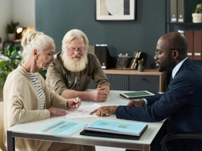 Senior Woman Signing Document At Meeting Senior woman signing document while sitting at meeting with financial manager